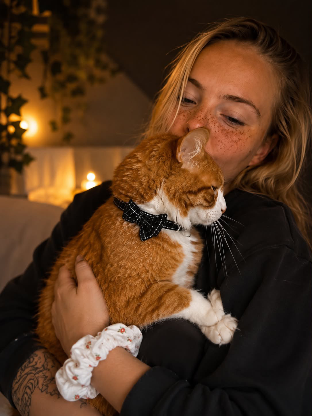 une femme portant un chat roux avec un noeud papillon noir anti-étranglement